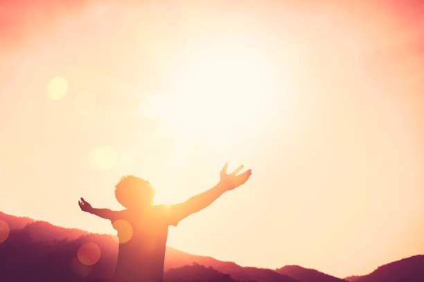 Copy space of man hand raising on top of mountain and sunset sky abstract background. Freedom travel adventure and business victory concept. Vintage tone filter effect color style.